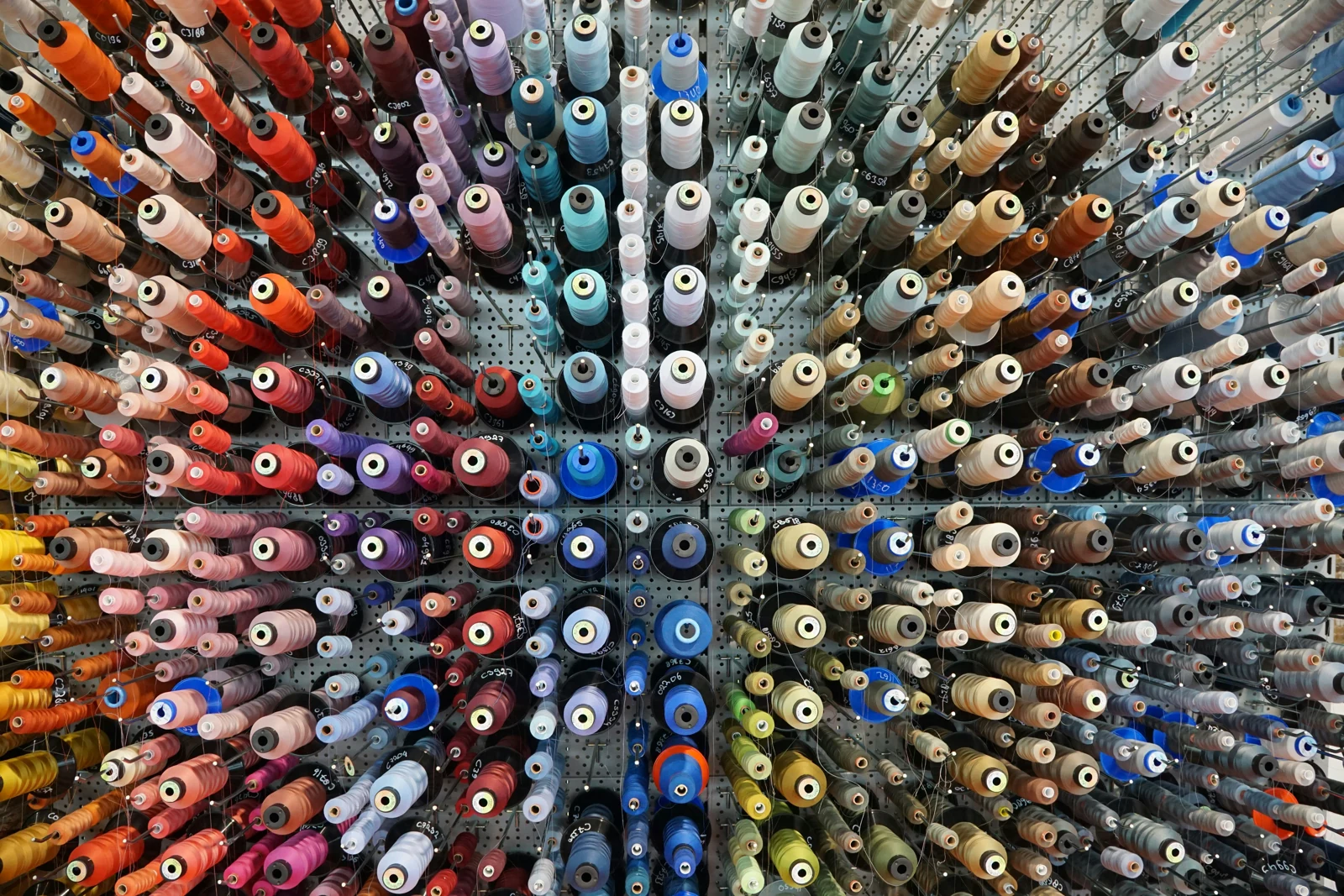 Una parete di rocche di filo colorato per le lavorazioni tessili.