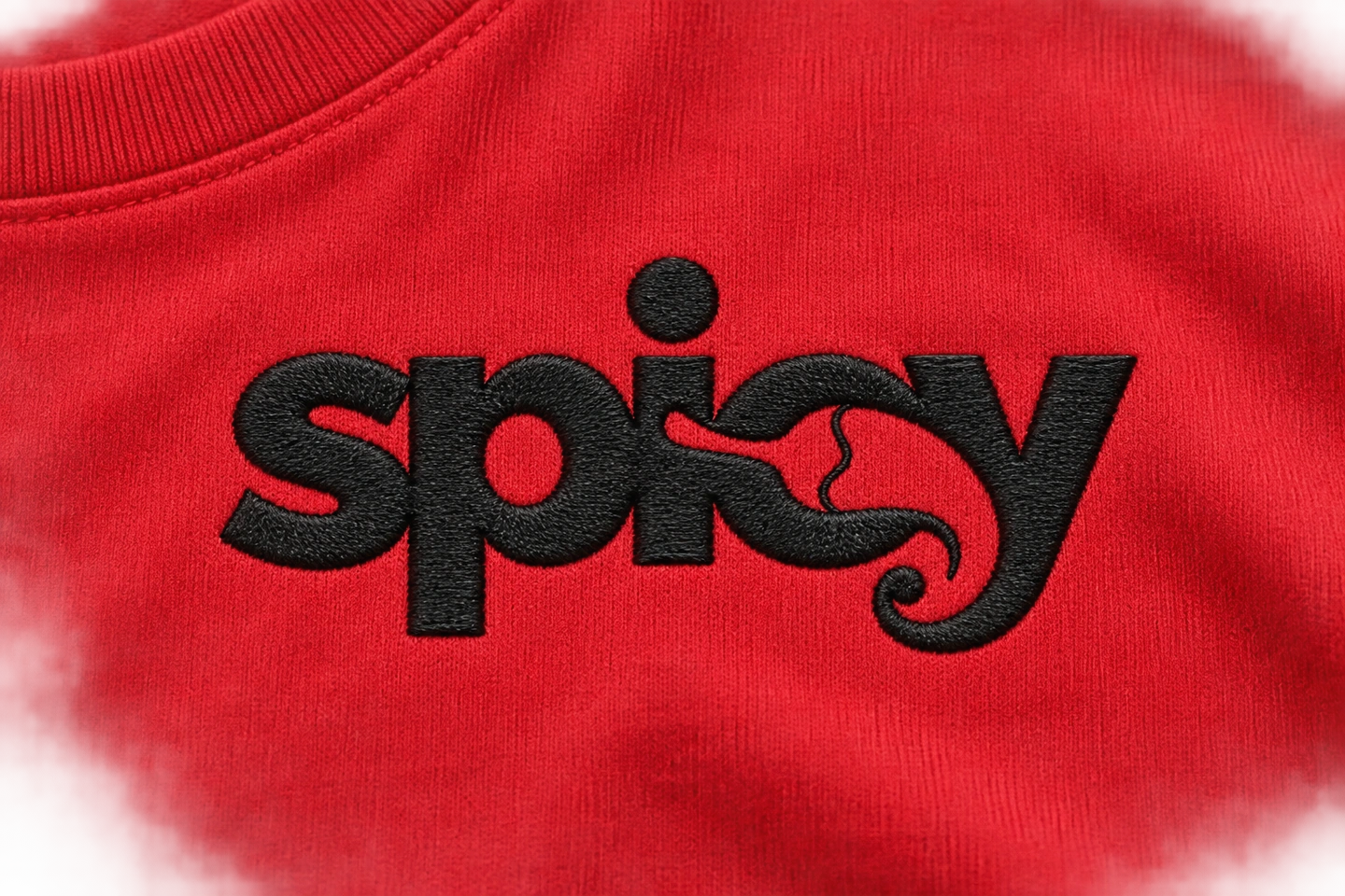 Dettaglio illustrativo del logo Spicy ricamato nero su tessuto rosso.